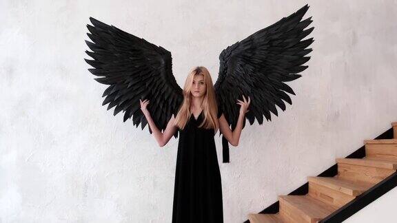 一个有着黑色天使翅膀和黑色裙子的女孩站在楼梯旁边