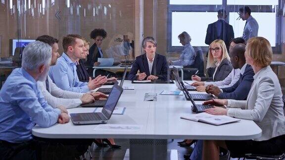 白人商务女性深色头发领导一个会议在玻璃会议室