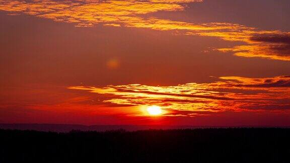 亮橙色的日落日落在云层后面
