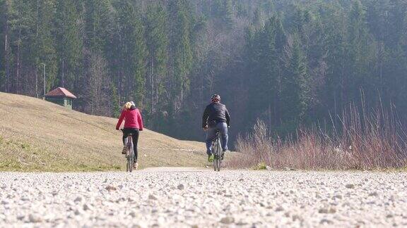 一名男子和一名女子骑自行车向前驶去