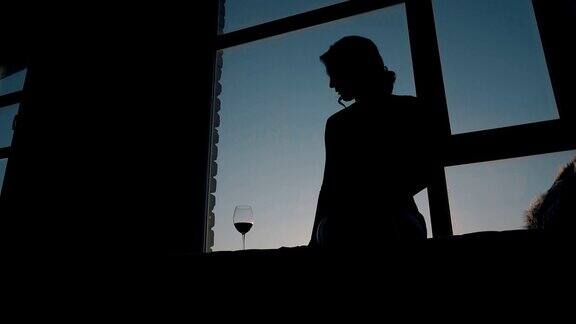 傍晚天空下女孩望着酒杯的剪影