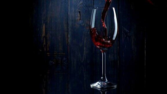 在深色的木质背景下将红酒倒入玻璃杯中慢动作