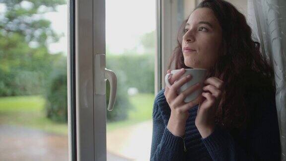 窗边喝咖啡的年轻女子
