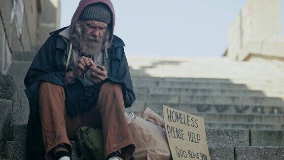 无家可归的老人一边在户外寻求帮助一边清点捐款