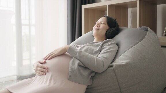 孕妇戴着耳机在休息室听音乐