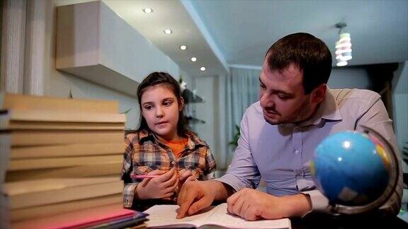 父亲帮助女儿做家庭作业父母帮助孩子