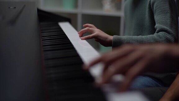 弹钢琴音乐老师在教小男孩演奏钢琴