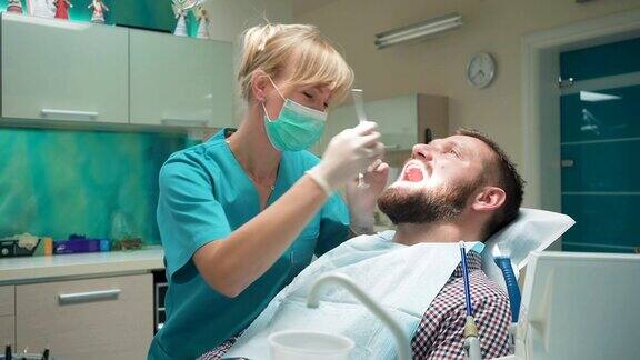 牙医正在检查病人的牙齿向他解释手术步骤