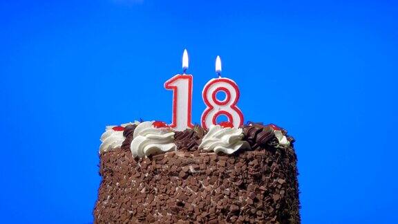 吹灭18岁生日蜡烛在美味的巧克力蛋糕上蓝屏