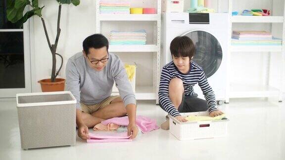 亚洲父亲和他的儿子在家里一起洗衣服家庭家务在一起