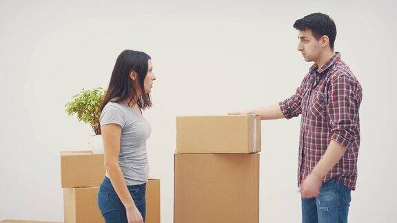 一对夫妇正搬进一套新公寓他们吵架了男人正在向女人扔盒子