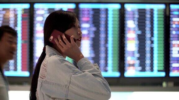 年轻的亚洲女孩在机场用智能手机检查登机牌准备旅行