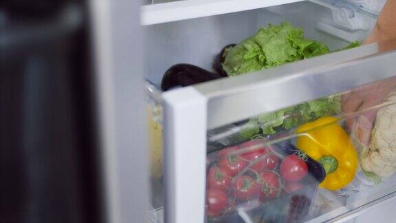 女人的手从冰箱里取出花椰菜