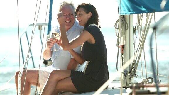一对成熟的夫妇在帆船甲板上喝香槟