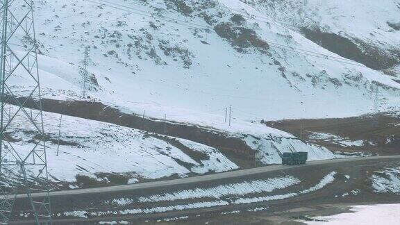 慢镜头:货车行驶在乡村公路上经过雪山