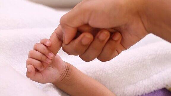 新生婴儿牵着妈妈的手指