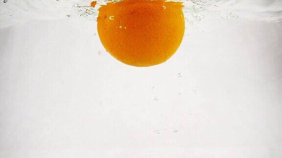一个橙子带着泡泡掉进水里慢动作视频