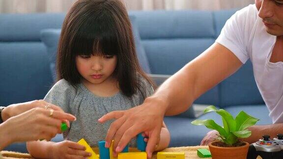 与家人共度时光爸爸妈妈和小女儿在客厅玩积木玩具家庭幸福理念