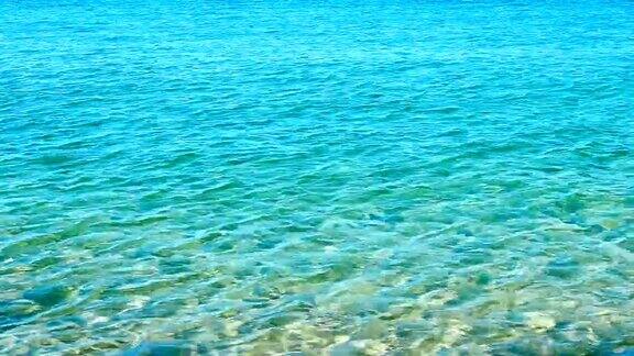 绿松石蓝色的海浪和海水在海滩上腐蚀夏天的背景