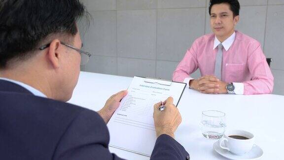 亚洲业务经理在会议室查看应聘者简历的面试评估表工作面试