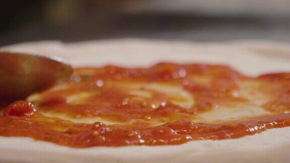 一个披萨厨师的手填充一个高质量的意大利美食配料如:火腿各种奶酪西红柿和新鲜的生物蔬菜