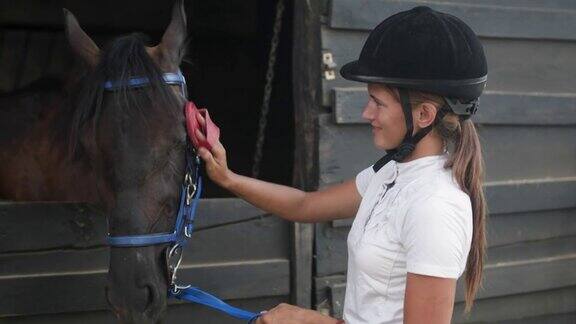穿着骑马装备的漂亮年轻女子抚摸着她的马