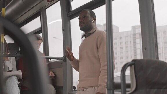 一名男子在公交车上戴着无线耳机说话
