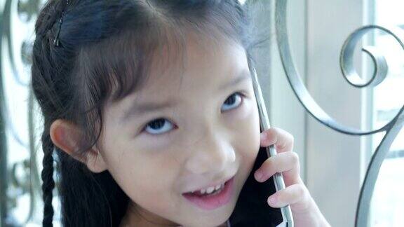 小女孩在窗边打电话
