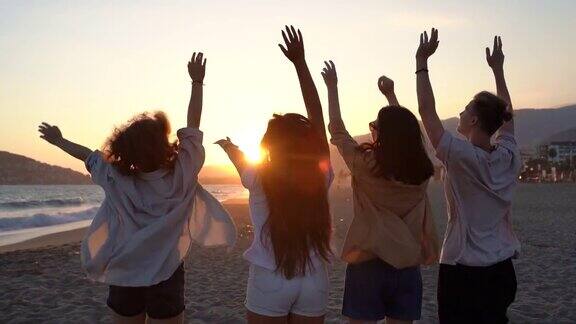 朋友们在热带海滩上享受夕阳欢笑漫步