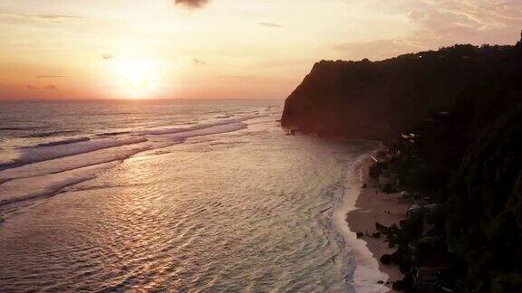 夕阳下的白色沙滩沿悬崖在巴厘岛
