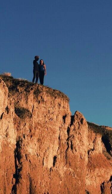 一对美丽的夫妇站在沙质山顶上