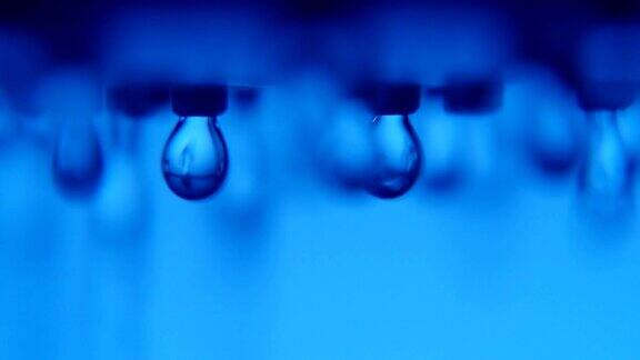 蓝色浴室里新鲜干净的水滴从金属喷射器上落下