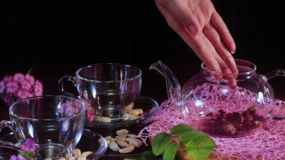 手把茶叶倒进茶壶里然后把开水倒进去茶道和传统桌上自制茶