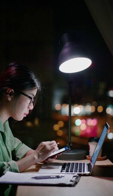 一个女人在晚上用笔记本电脑学习电子学习