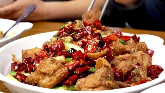 中国餐馆里人们在餐桌上吃辣炸鸡的动作