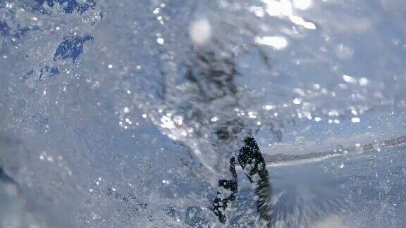 慢镜头:一个冲浪者在冲浪板上做了一个急转弯溅到照相机上