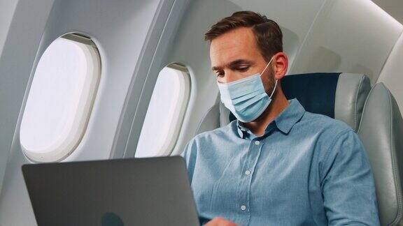 在飞机上带着笔记本电脑的人