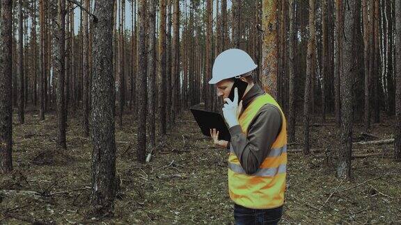 工程师检查员在伐木前打电话询问森林的情况头戴头盔和背心的老板用手势挥舞他的手斥责或斥责他的下属自然保护