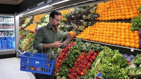 成熟的男人在超市买水果