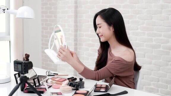 年轻的亚洲女性美容视频博主录制化妆教程