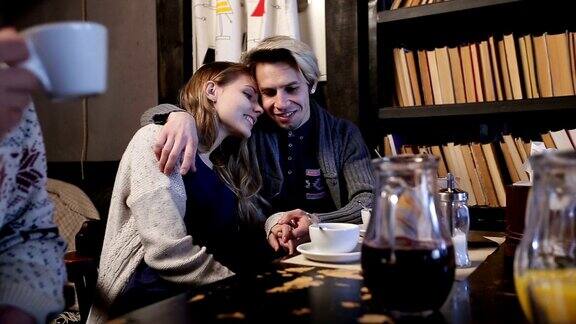 迷人的青少年情侣在咖啡馆里拥抱相爱