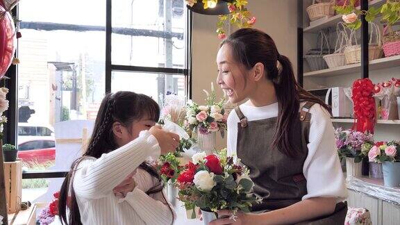 一家亚洲花店的老板和他的女儿帮助安排花店内的鲜花为出售做准备一个日本女人与专业花店小的经营理念