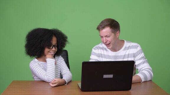 年轻的非洲女孩和年轻的斯堪的纳维亚男人一起使用笔记本电脑