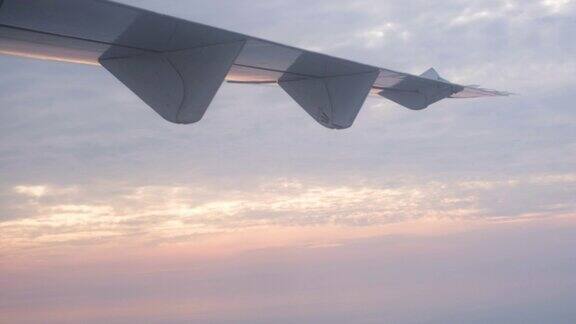 飞机机翼与云和蓝天在日出时飞行
