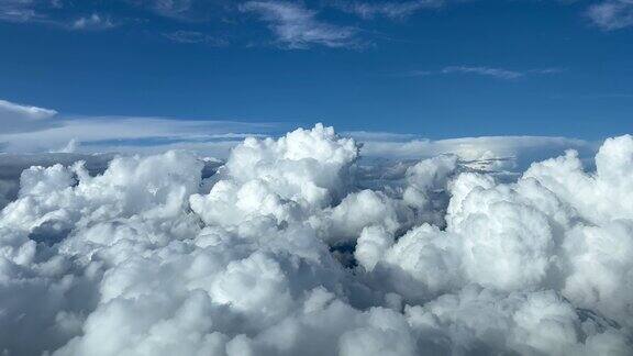 从飞机驾驶舱俯瞰暴风雨般的积雨云湛蓝的天空飞行员的观点4k60帧