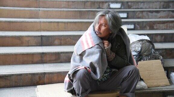 无家可归的人给自己盖上毯子以防天气寒冷