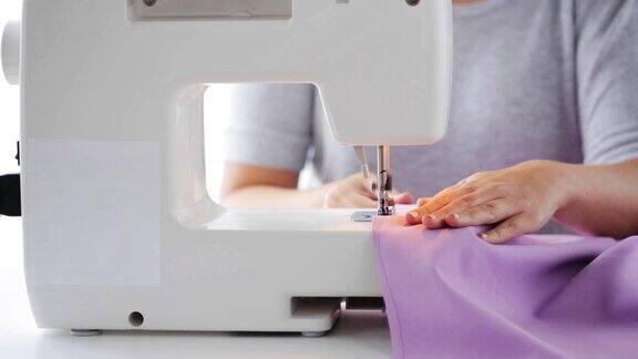 用缝纫机缝制布料的裁缝