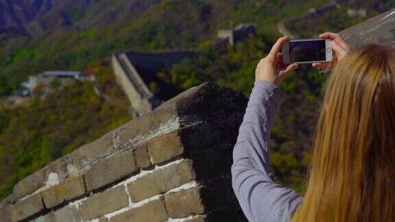 2018年10月29日中国北京:一名女子用手机拍摄中国长城的慢动作照片长城在山的一侧开始倒塌