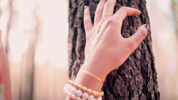 女人的手戴着珠宝在森林里有临时纹身