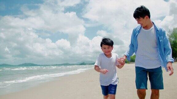 暑假里父子俩在沙滩上嬉戏奔跑